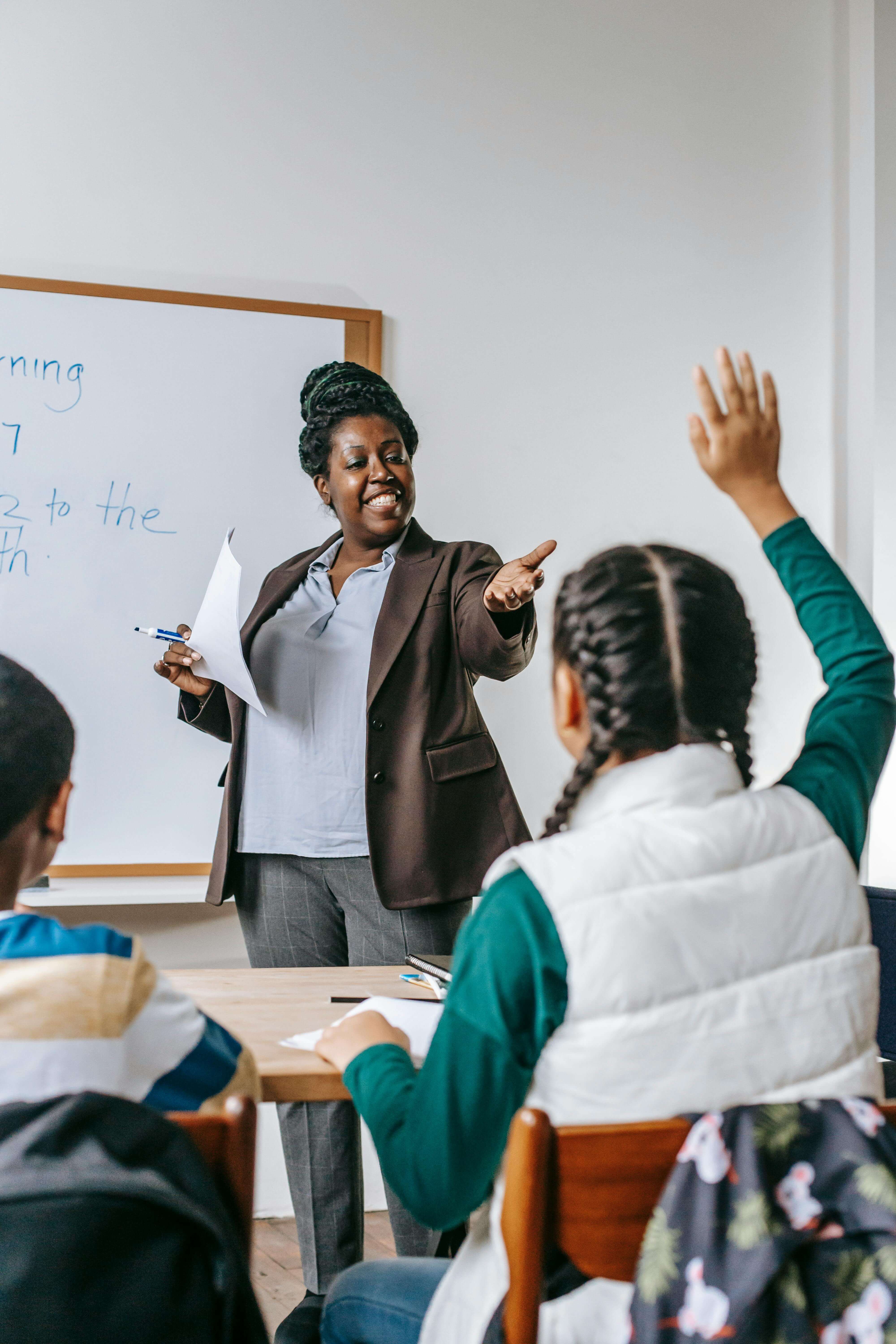 Teacher engaging enthusiastically with students in an active classroom environment